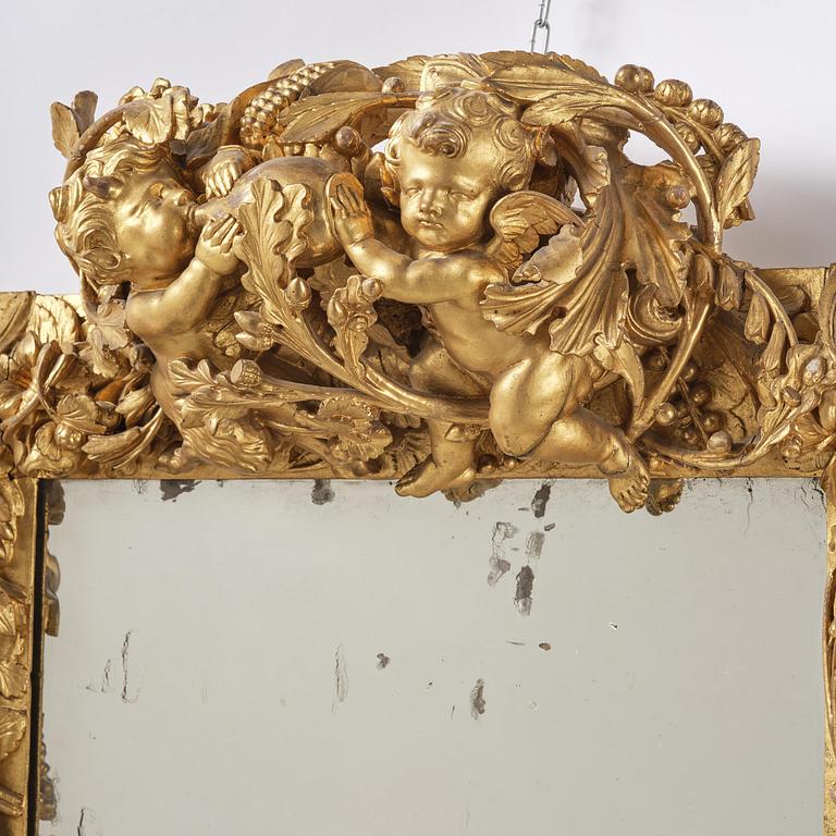 A presumably Dutch Louis XIV carved giltwood frame with mirror glass, in the style of Jean Le Pautre, late 17th century.