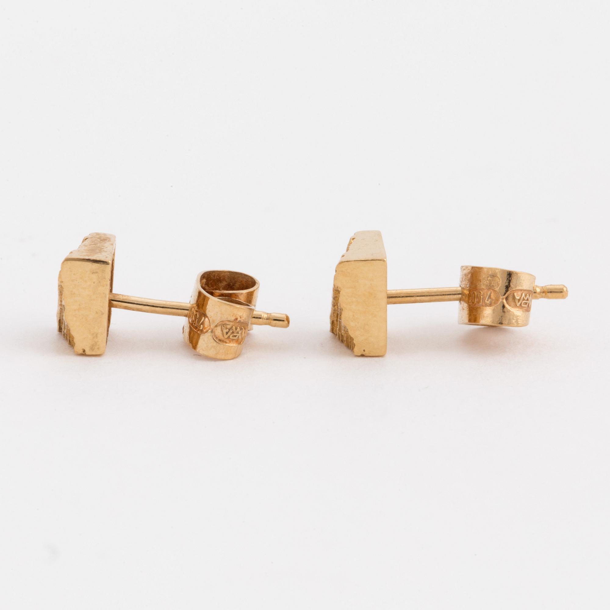 A pair of earrings with a textured surface.