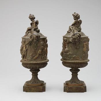 A pair of 19th century bronze urns in the manner of Clodion.