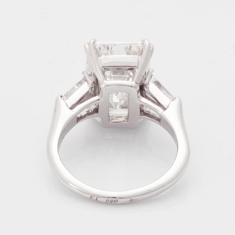 A platinum ring set with an emerald-cut diamond.