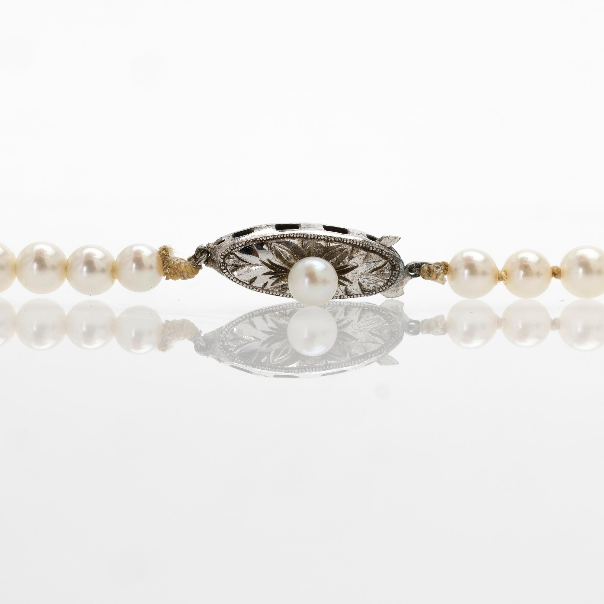 Necklace of graduated cultured pearls with a silver clasp.