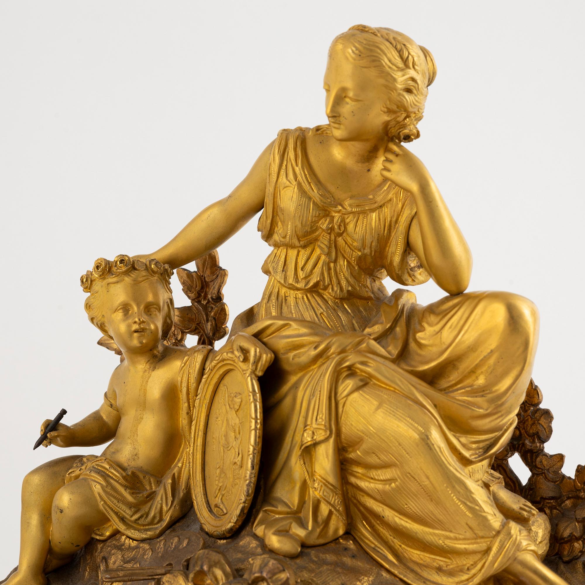 A table clock and a pair of candelabras, Louis XVI-style, France, beginning of the 20th century.