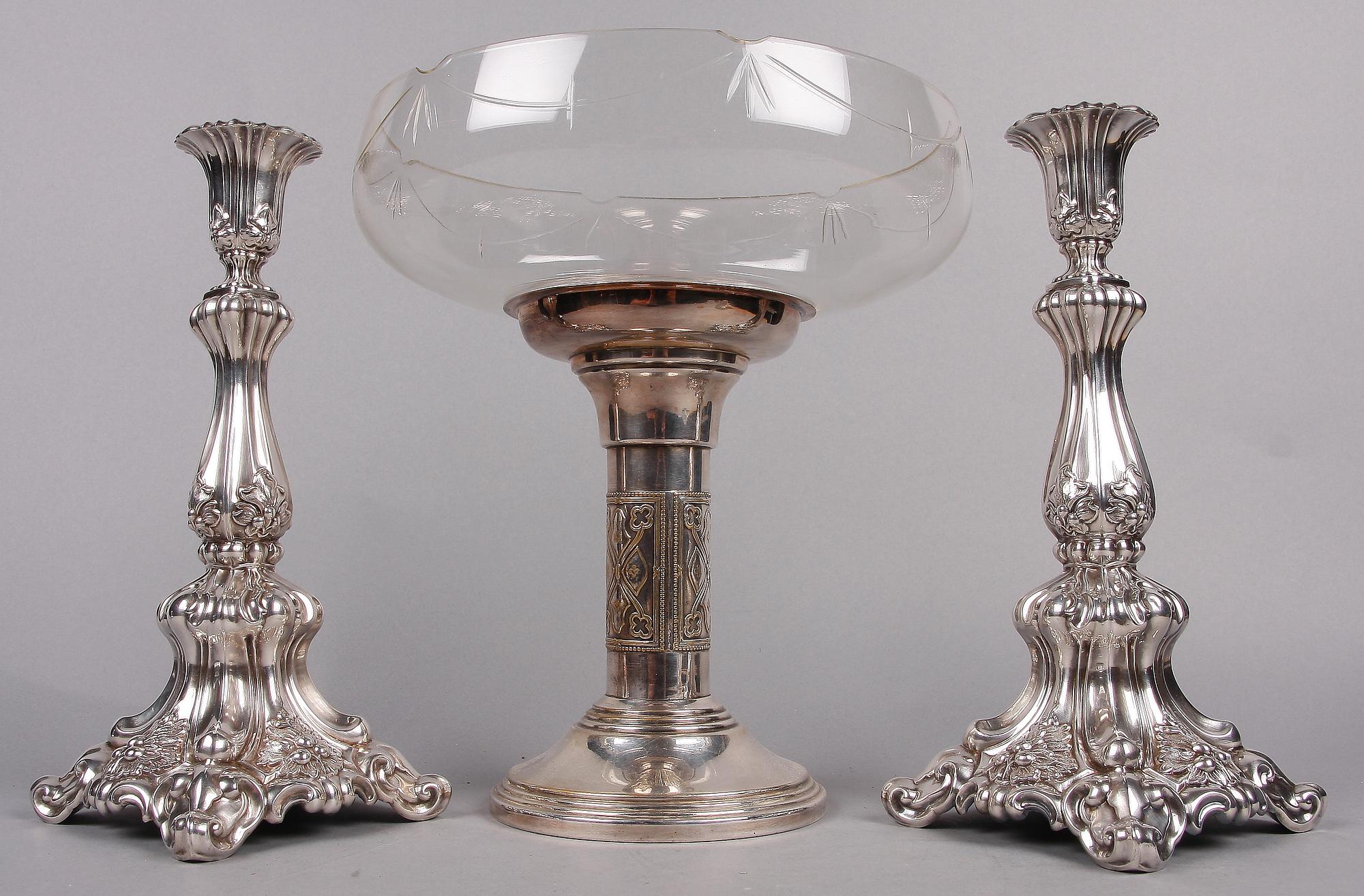 SKÅL PÅ FOT SAMT LJUSSTAKAR ett par, nysilver, 1900-talets första hälft.