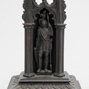 A neo-gothic cast iron pocket watch stand with a pocket watch. 19th century.
