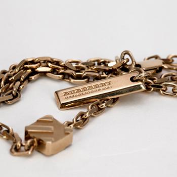 BURBERRY, a gold colored necklace.