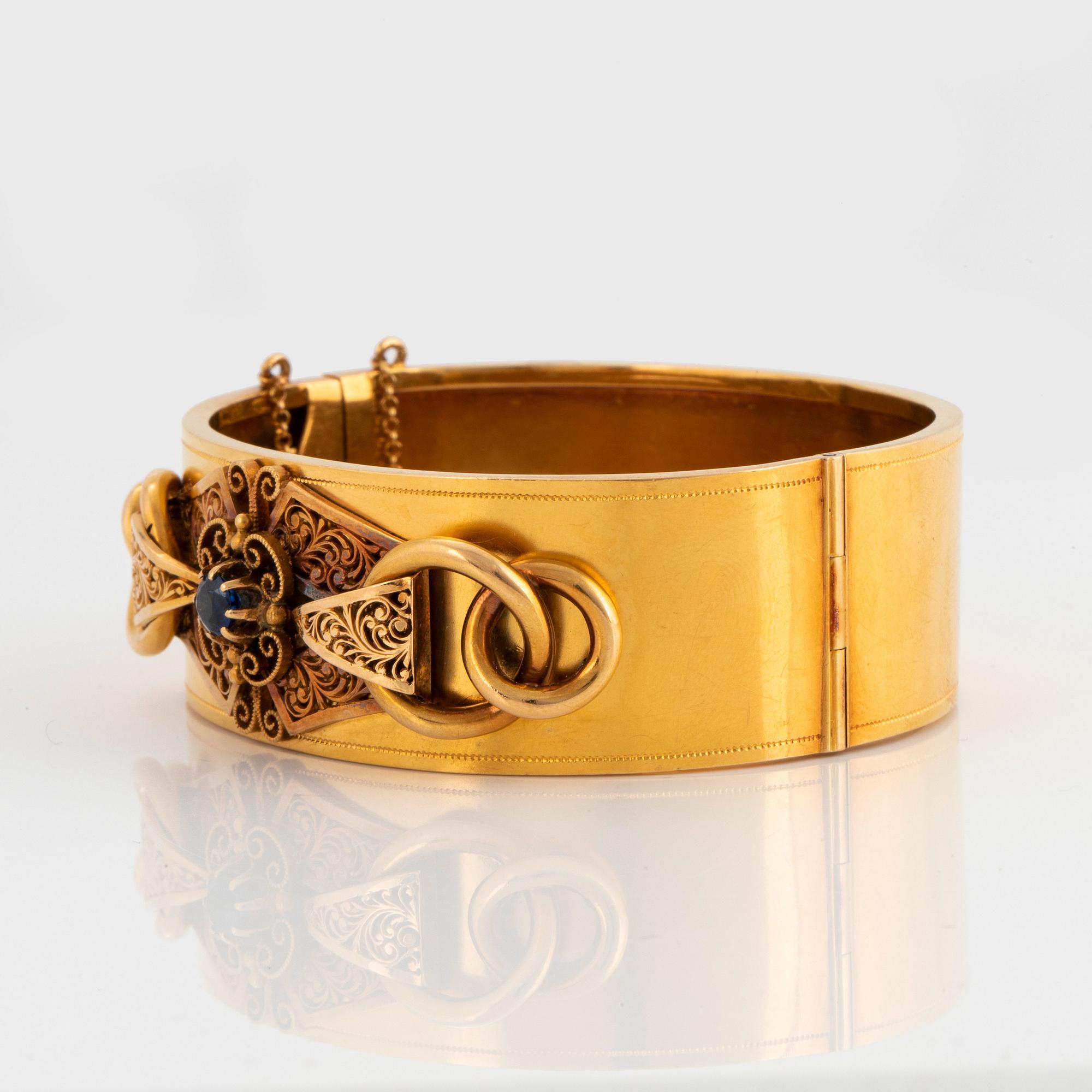 Armring 18K guld med en fasettslipad safir.