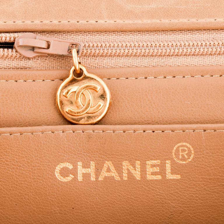 CHANEL, a beige leather flap bag.