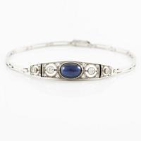 A bracelet in platinum set with old-cut diamonds and a blue stone.