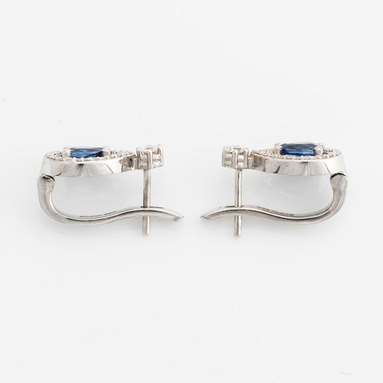 A pair of 14K gold earrings with faceted sapphires and round brilliant-cut diamonds.