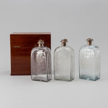 A late Empire mahogany box with three glass bottles, mid 19th Century.