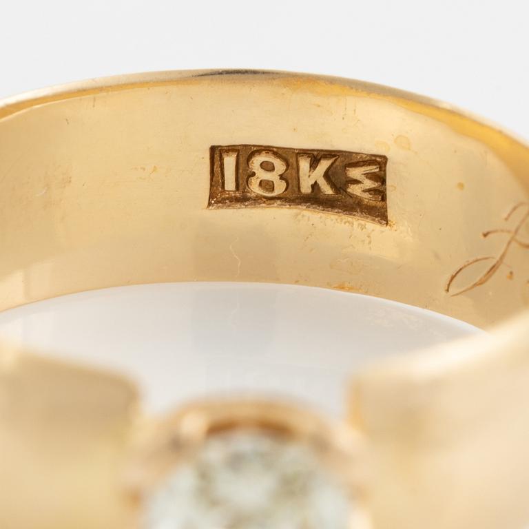 An 18K gold ring set with a radiant-cut diamond.