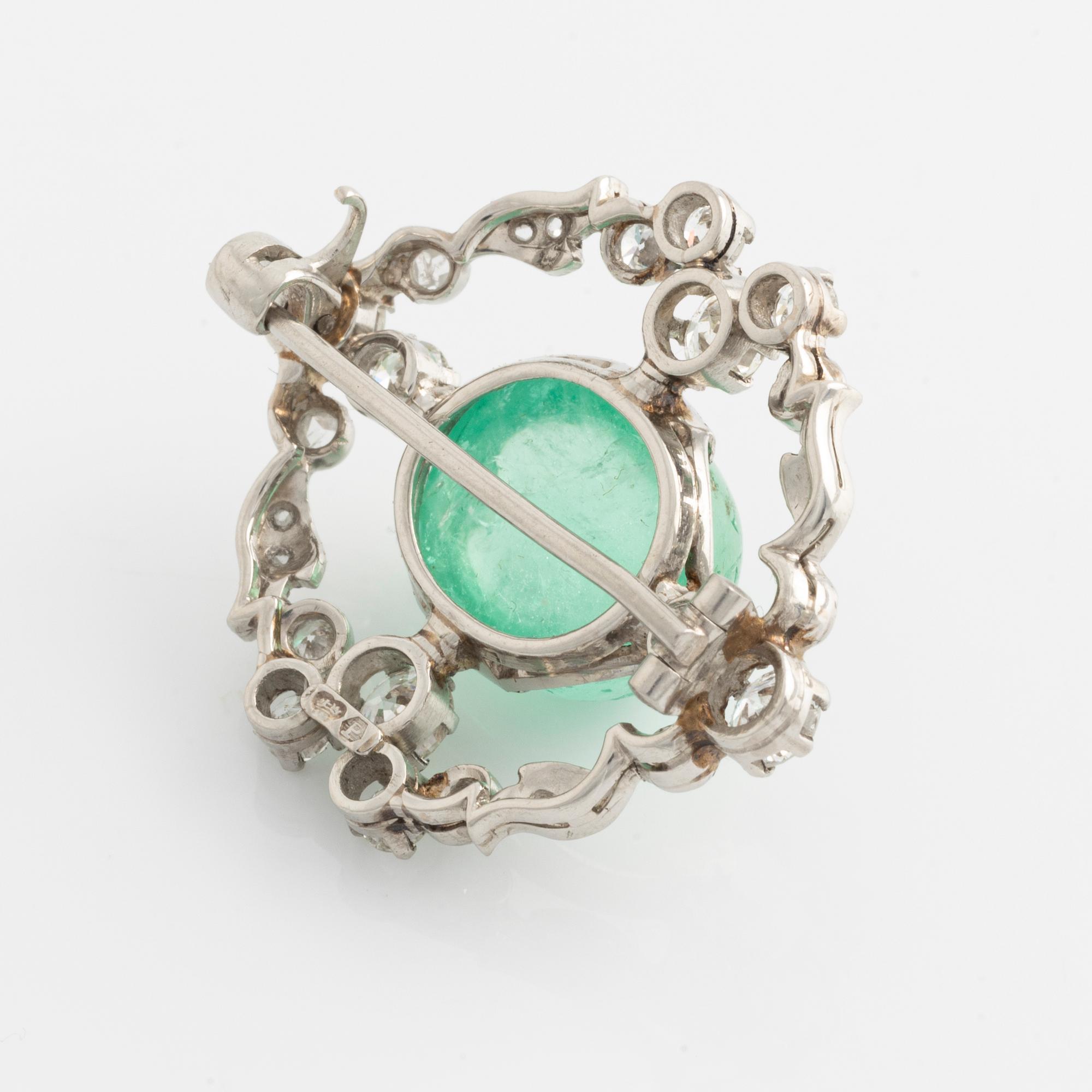 A platinum brooch with a cabochon-cut emerald.