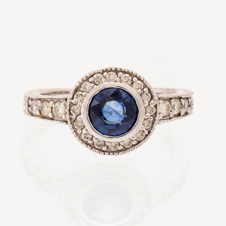 Ring in 18K white gold with a round faceted sapphire and round brilliant-cut diamonds.