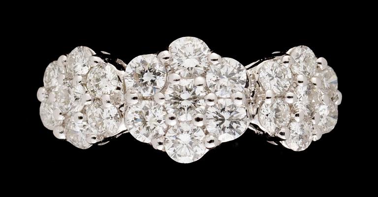 RING, 14k vitguld med 21 briljantslipade diamanter i tre rosetter.
