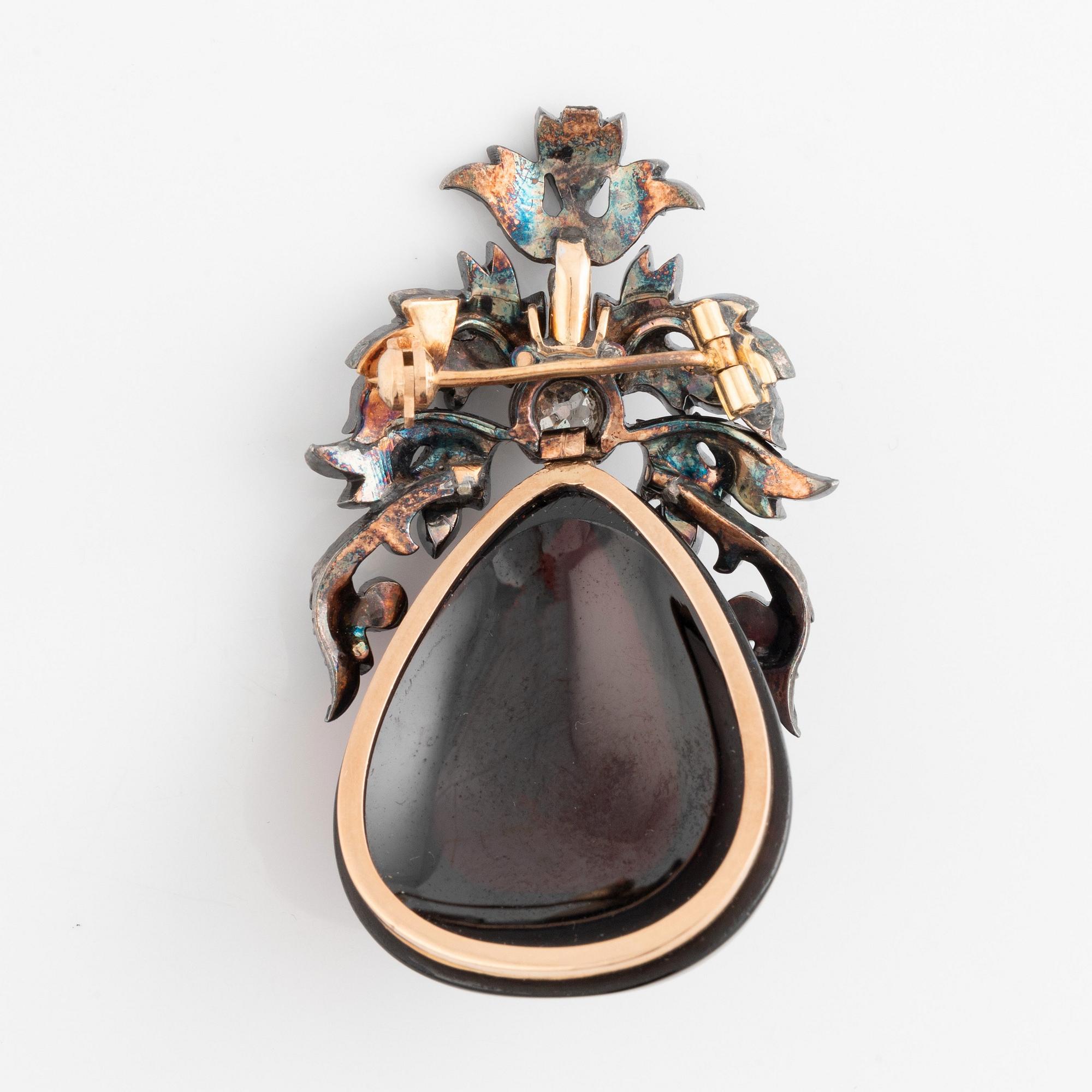 A silver and gold brooch set with a large carbuncle garnet. - Bukowskis