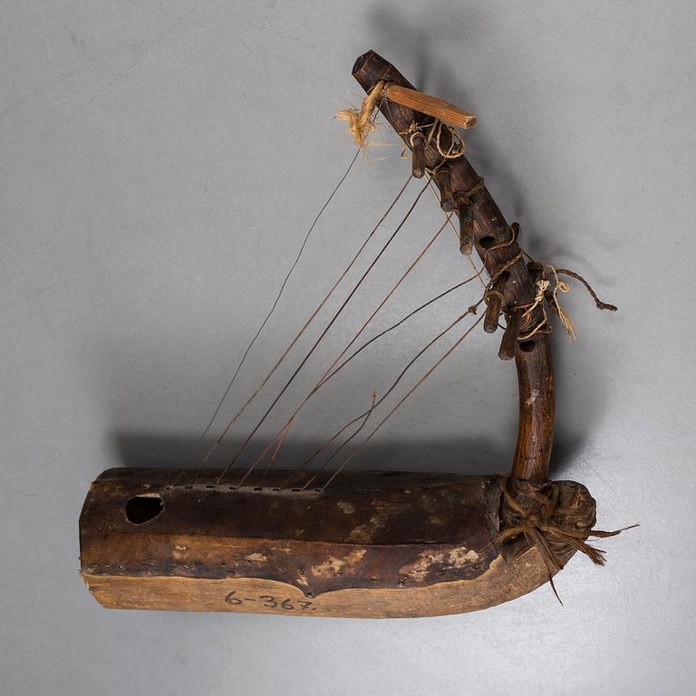 A STRING INSTRUMENT, wood, leather and rope, Africa first half of the 20th century, length 39,5 cm.