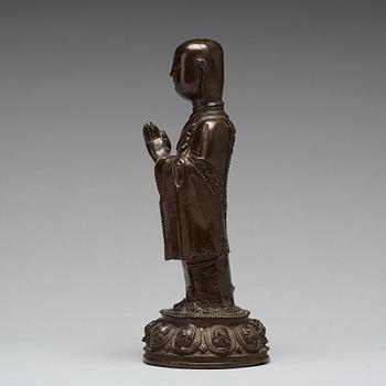 A bronze figure of a standing buddha, late Ming dynasty (1368-1644).