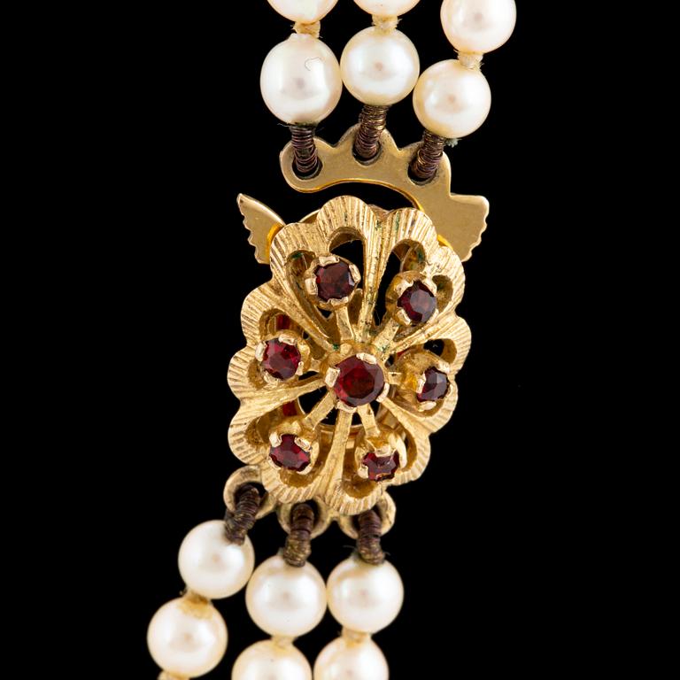 A three strand cultured pearl necklace.
