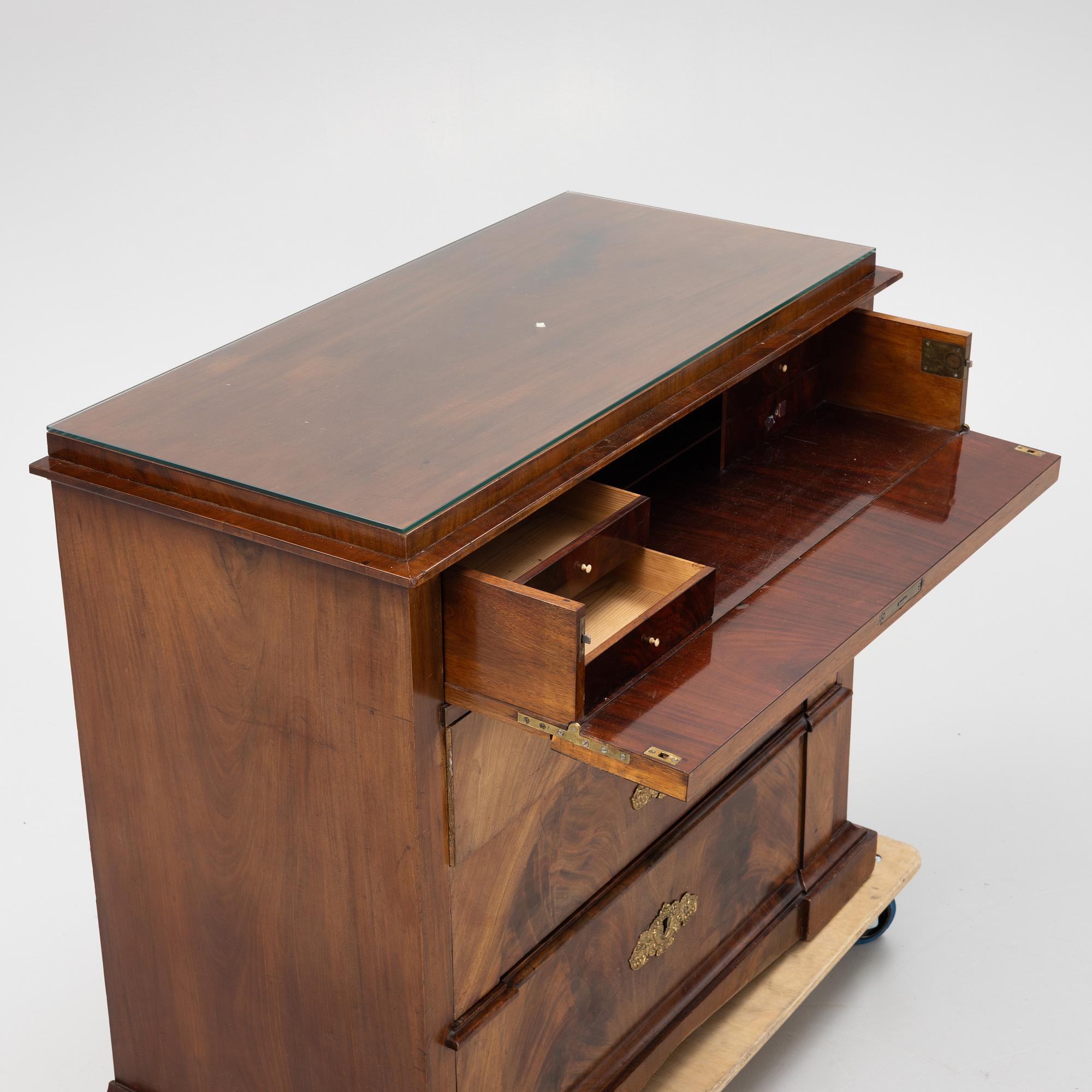 A mahogany veneered Empire chest of drawers, first half of the 20th Century.