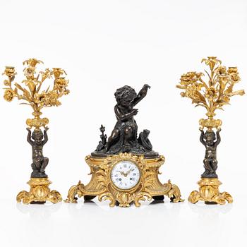 A Rococo style mantle clock and pair of candelabra, France, late 19th Century.