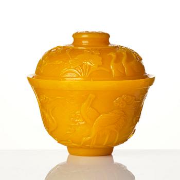 A well carved yellow glass 'crane and lotus' cup with cover, presumably late Qing dynasty.