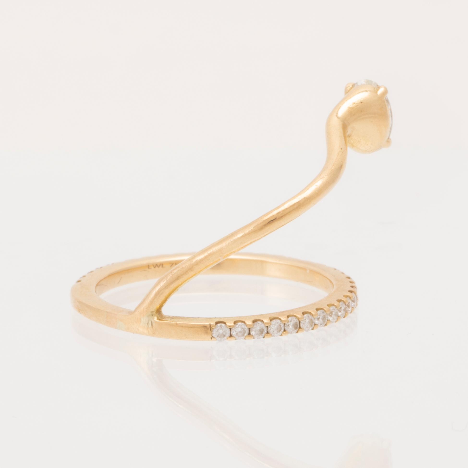 An 18K gold ring set with an oval cut and round brilliant cut diamonds by LWL Jewelry.