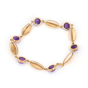 A bracelet with round, cabochon-cut amethysts.