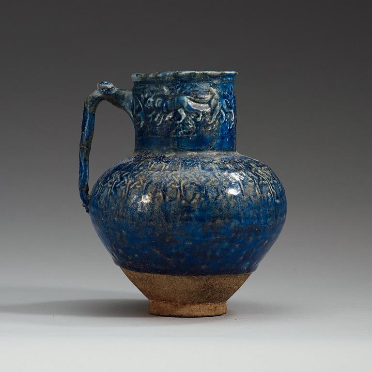 A JUG, pottery with a blue glaze. Height 18,5 cm. Persia (Iran) 12th-13th century, possibly Rayy.