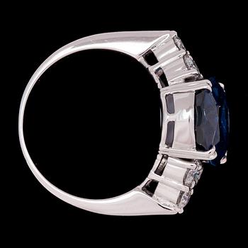 RING, oval fasettslipad blå safir, ca 4.50 ct med briljantslipade diamanter, tot. ca 0.60 ct.