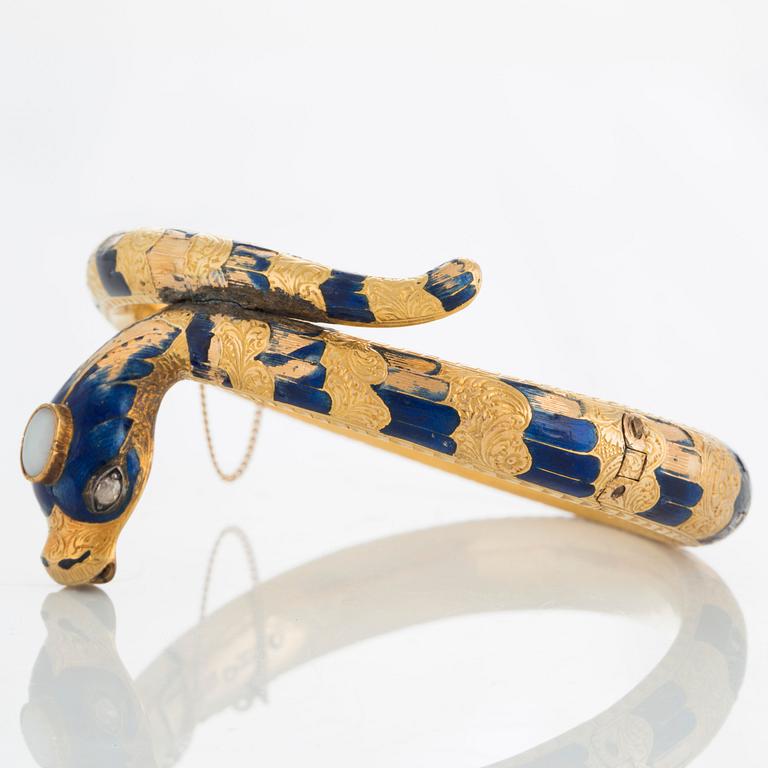 An 18K gold snake bangle decorated with blue enamel and set with an opal and a rose-cut diamond.