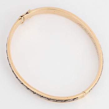 An 18K gold bangle.