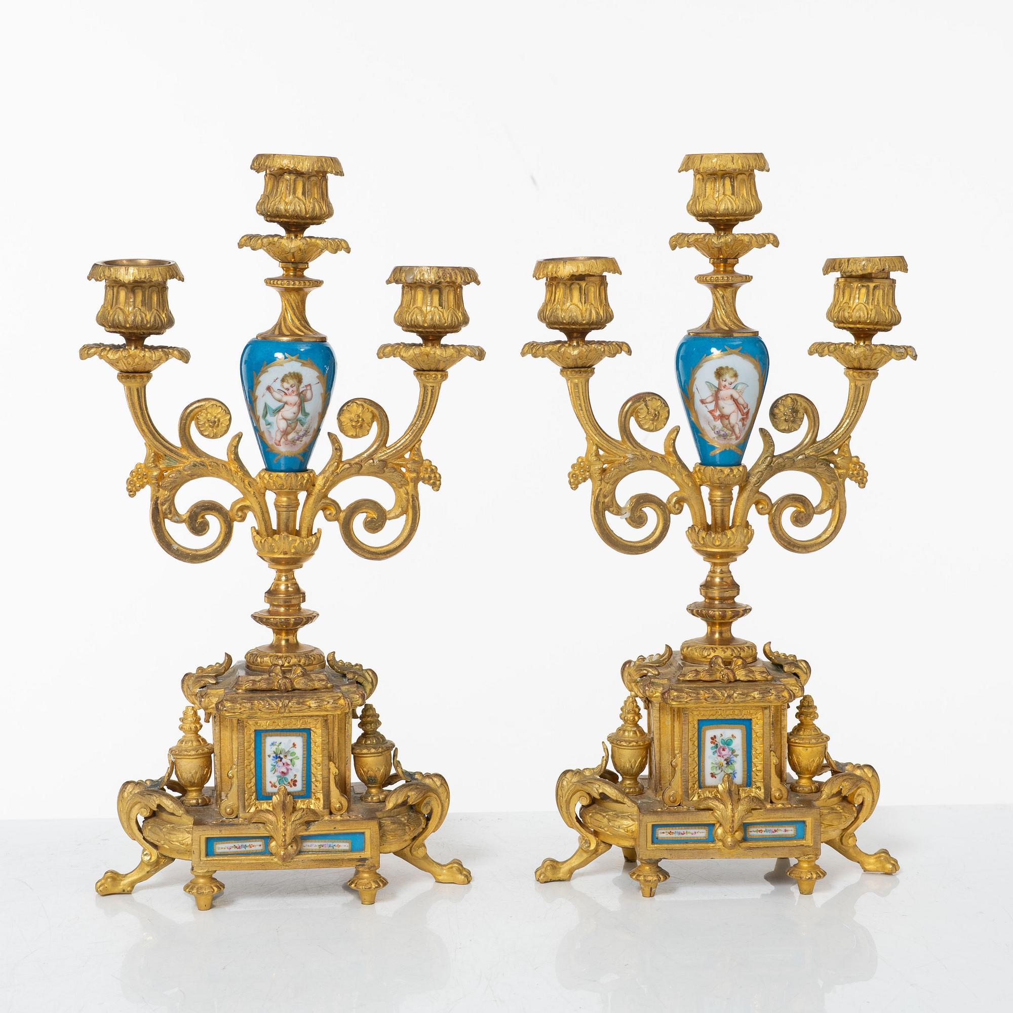 A French Louis XVI-style mantel clock and a pair of candelabra, late 19th Century.
