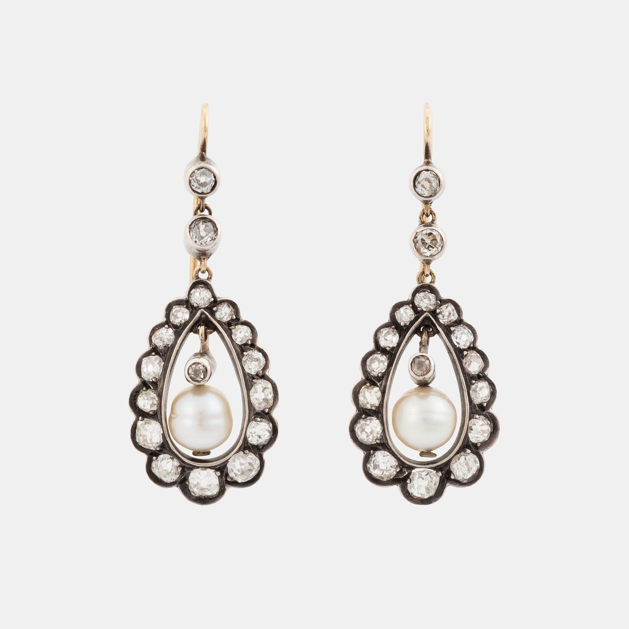 A pair of silver and gold earrings set with old-cut diamonds and pearls.