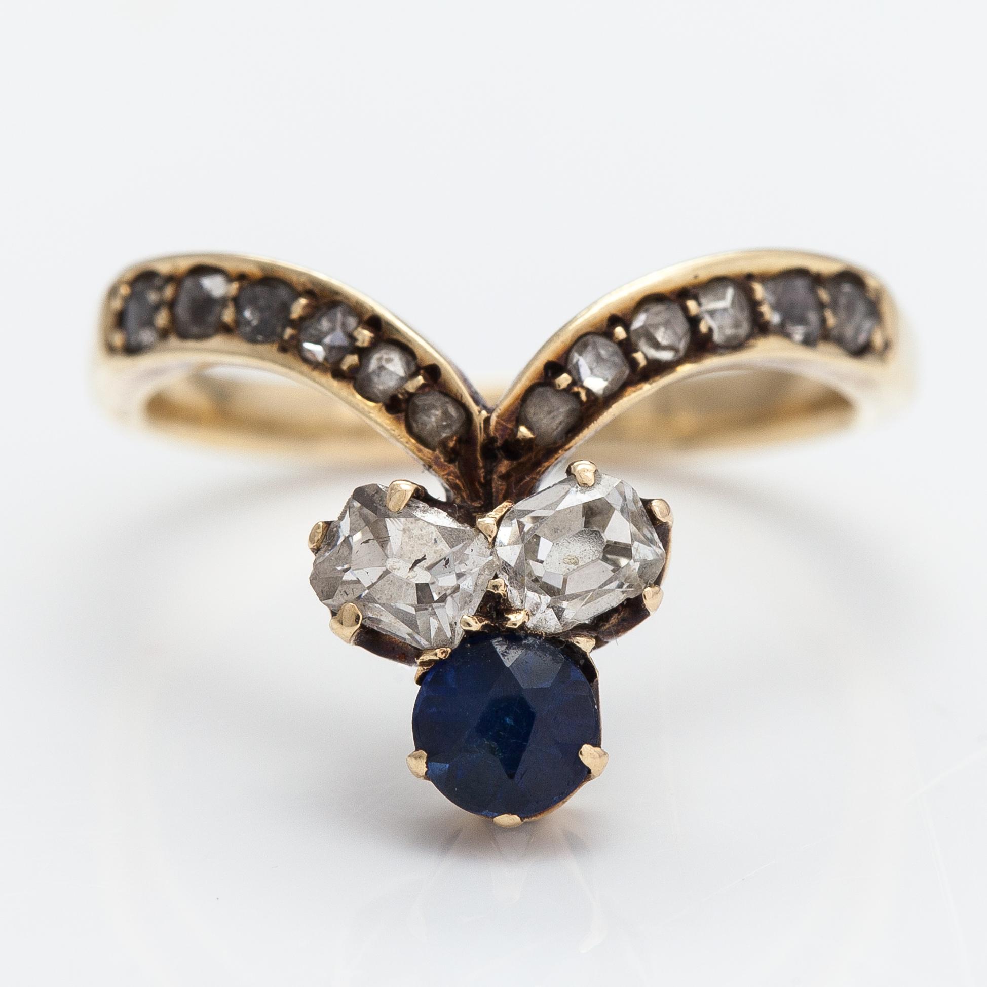 A 14K gold ring with a synthetic sapphire, radiant-cut diamonds ca. 0.28 ct in total and rose cut diamonds.