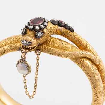 A Victorian snake bracelet in 14K gold with rose-cut diamonds, red stones and a half pearl.