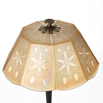 A 1920's patinated metal, lacquered wood, etched och cut glass table lamp, unknown designer, 1920's.