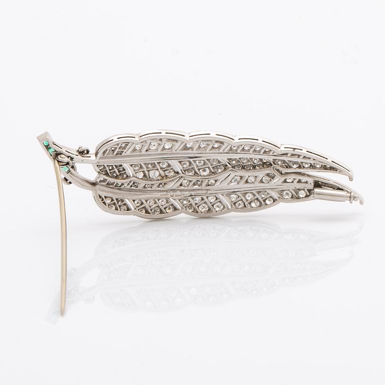Brosch platina med runda briljantslipade diamanter samt smaragder.