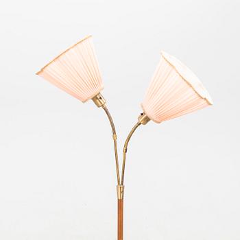 A teak and brass floor lamp from the first half of the 20th century.