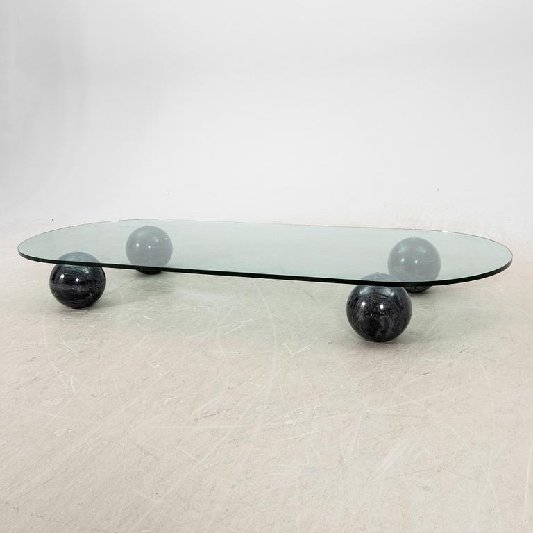 A glass and stone table from the late 20th century.