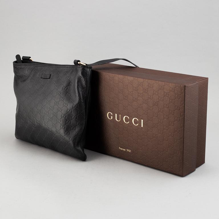 Gucci, a leather messenger bag.