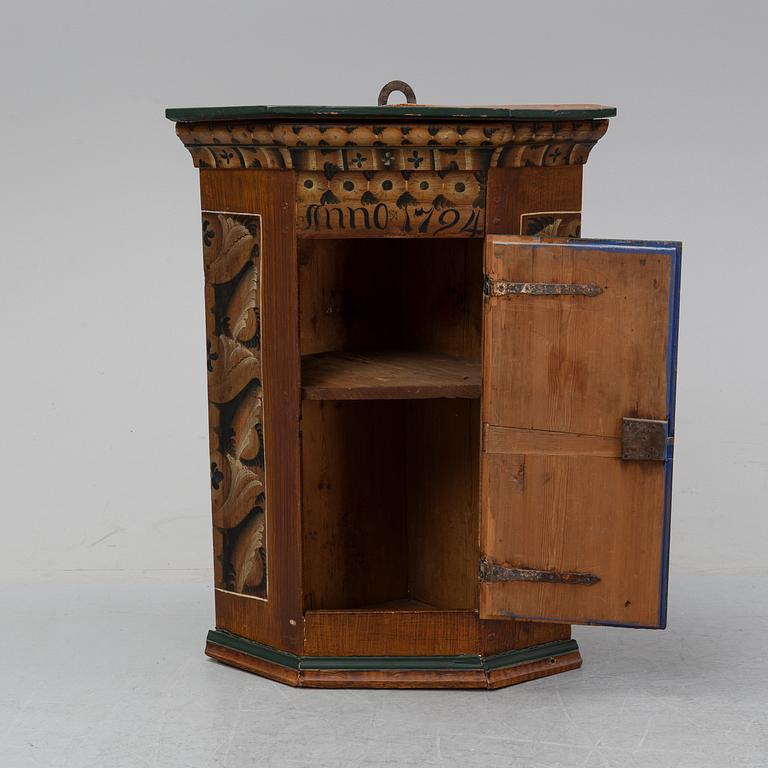 A painted corner cabinet, dated 1794.