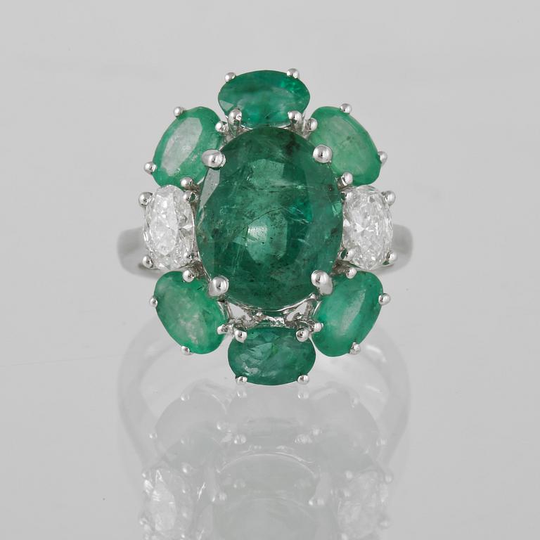 RING, 18K vitguld med 2 ovalslipade diamanter 0.63 ct samt ovalslipad smaragd 5.28 ct samt 6 mindre smaragder 2.90 ct.