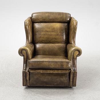 A leather upholstered easy chair with stool, second half of the 20th Century.