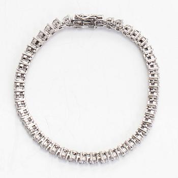 An 18K white gold tennis bracelet, with brilliant-cut diamonds.