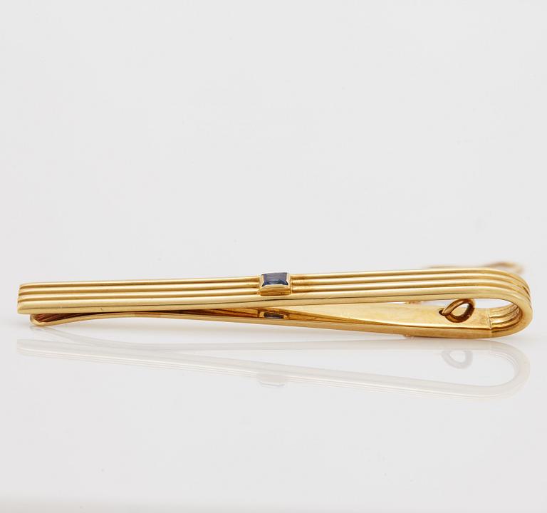 A 1960/70's tie-clip decorated with a carré-cut sapphire by Dupont, Paris.