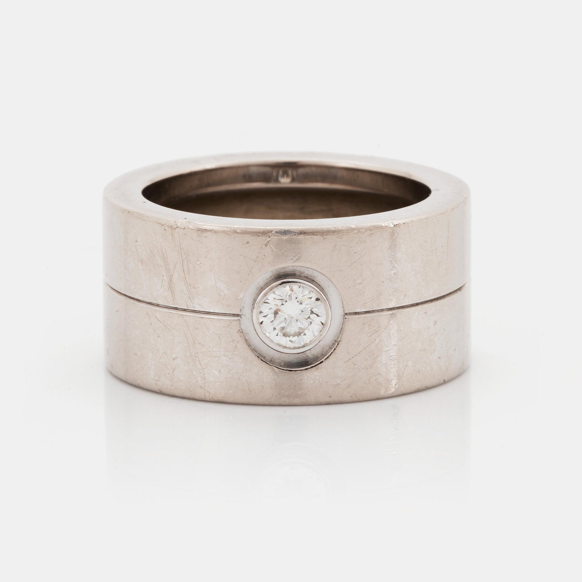 A Cartier 18K white gold ring set with a round brilliant-cut diamond.