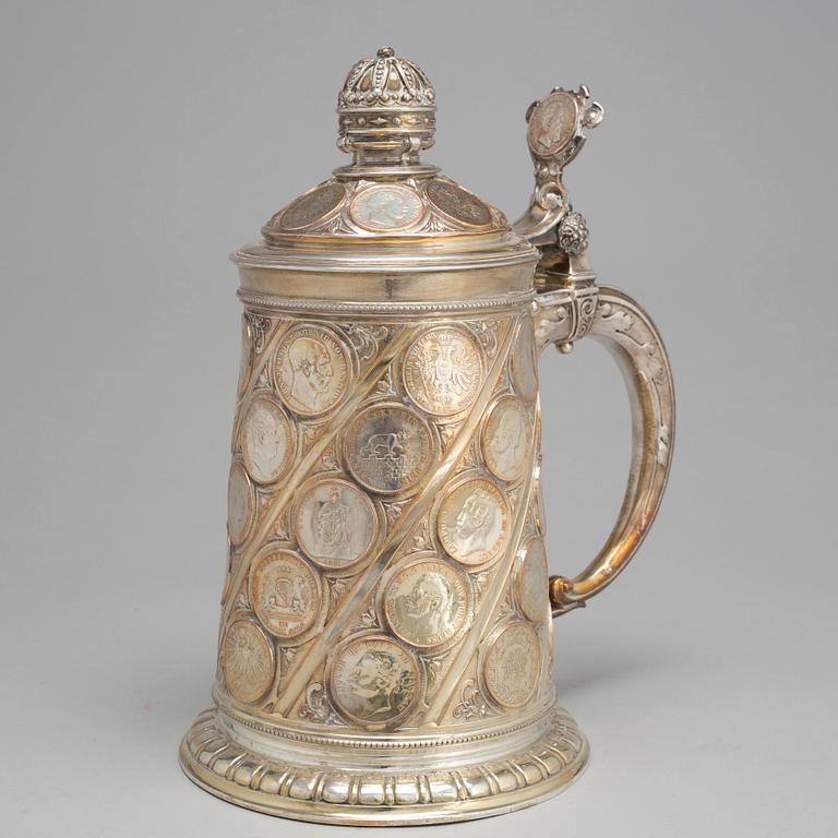A late 19th century EPNS tankard with silver coins.