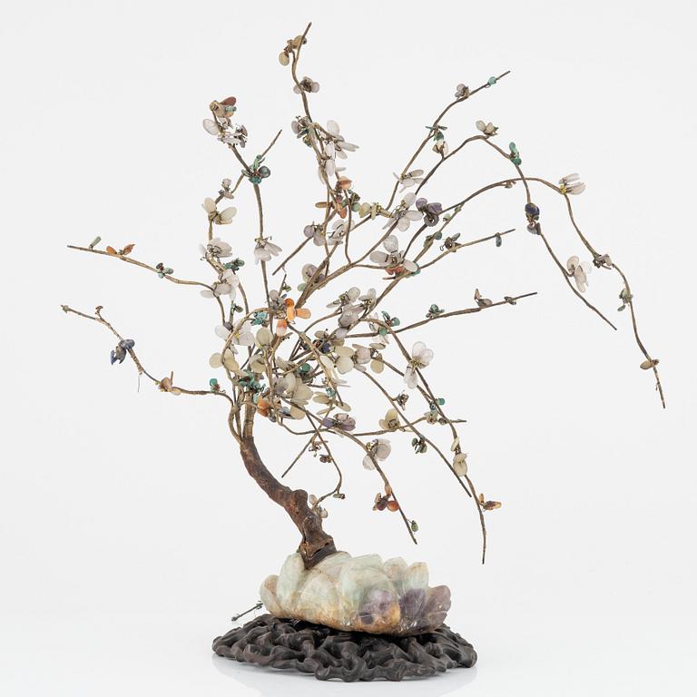 A decorative sculpture of a tree, made from nephrite, quartz, turkoise and lapis lazuli. China, 20th Century.