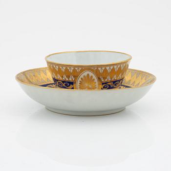 A blue and white porcelain tea cady, late Qing dynasty, 19th century, and a porcelain cup with saucer, Qing Dynasty, 19th century.