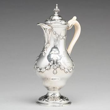 An English 18th century silver hot water-jug, mark of Chas Woodward, London 1773.